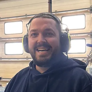 Mann med hodetelefoner og svart hettejakke